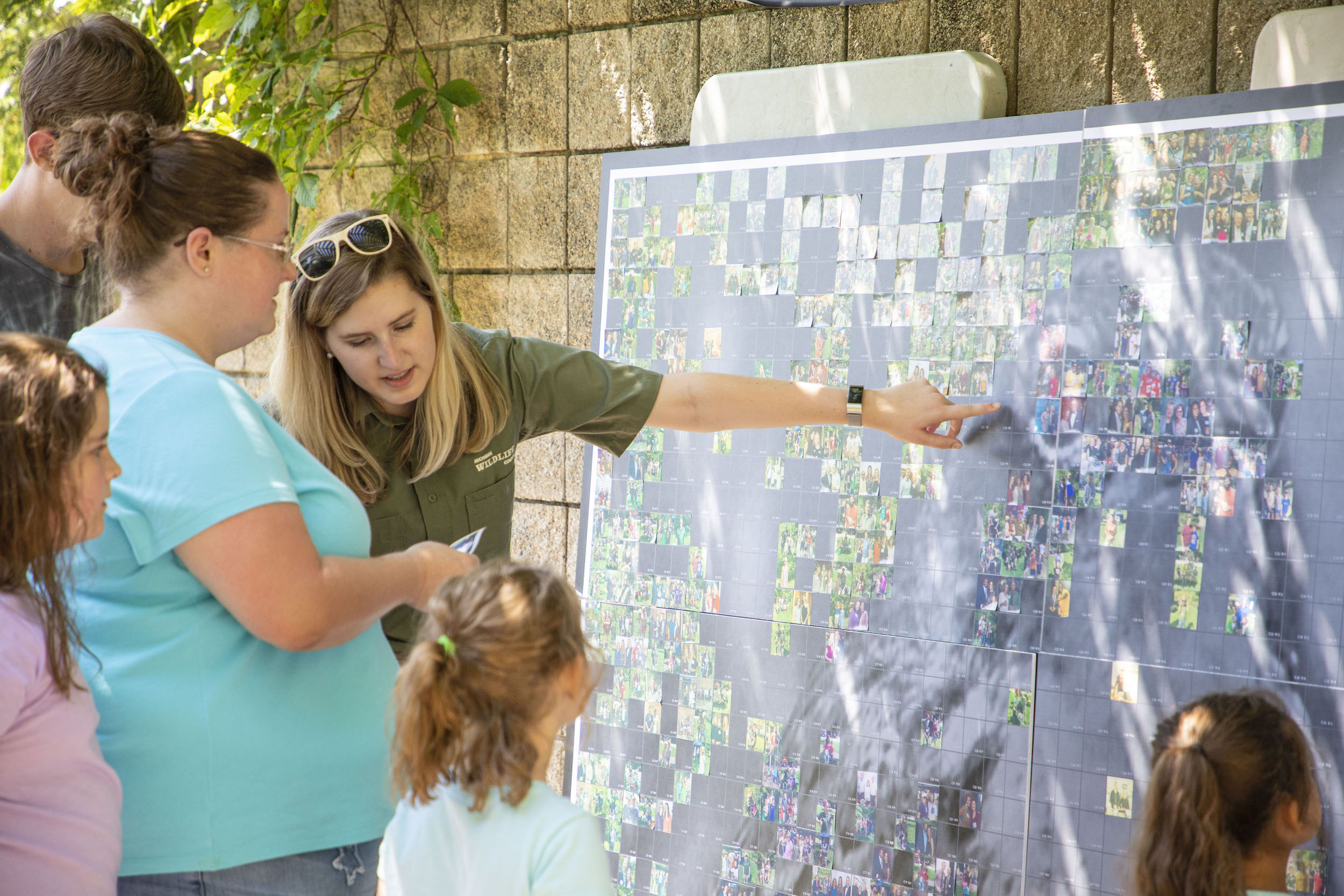 People gather around a large photo mosaic