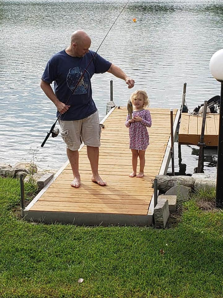 Father and daughter show fish they caught