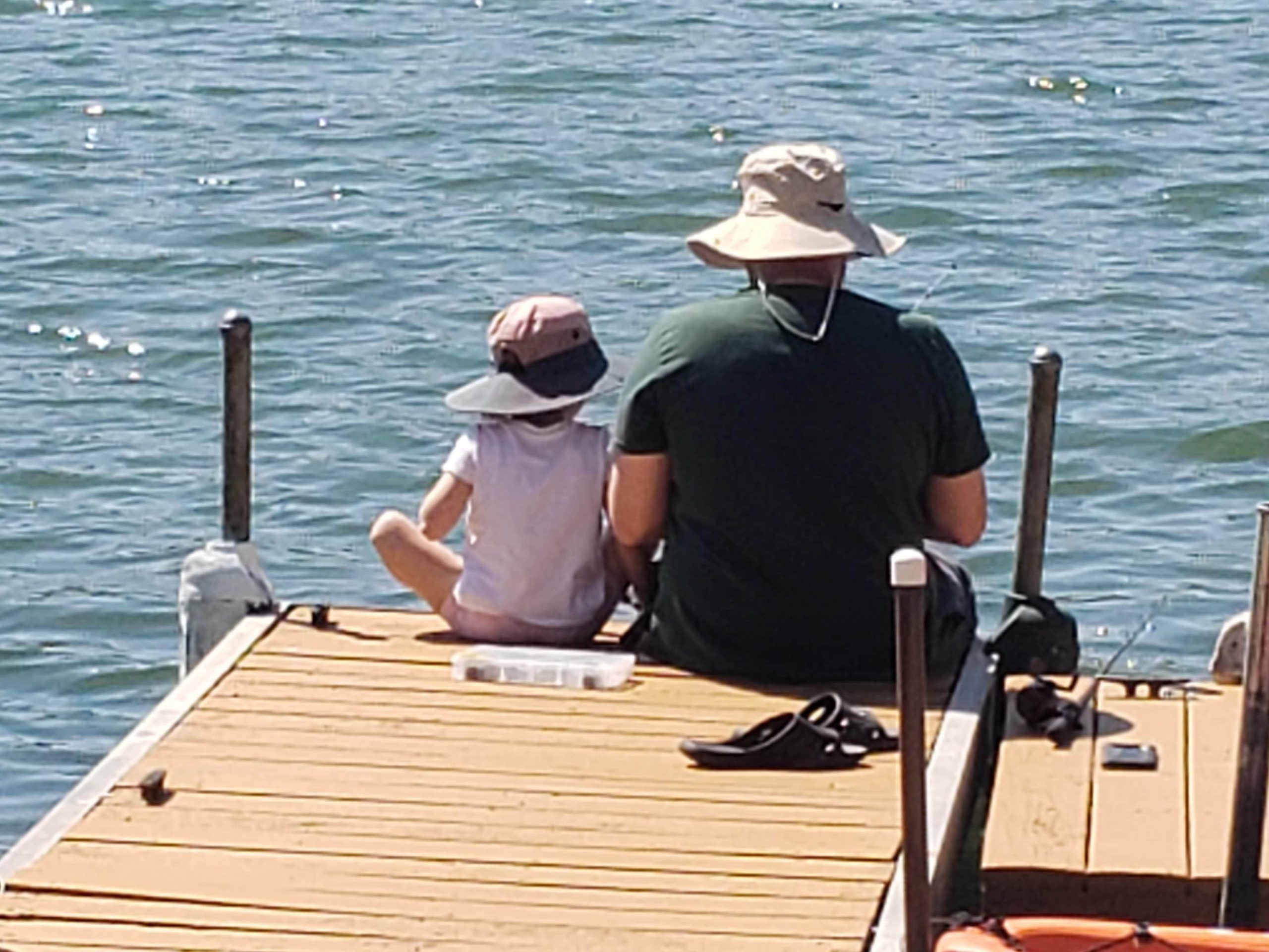 Father and daughter fishing off a dock